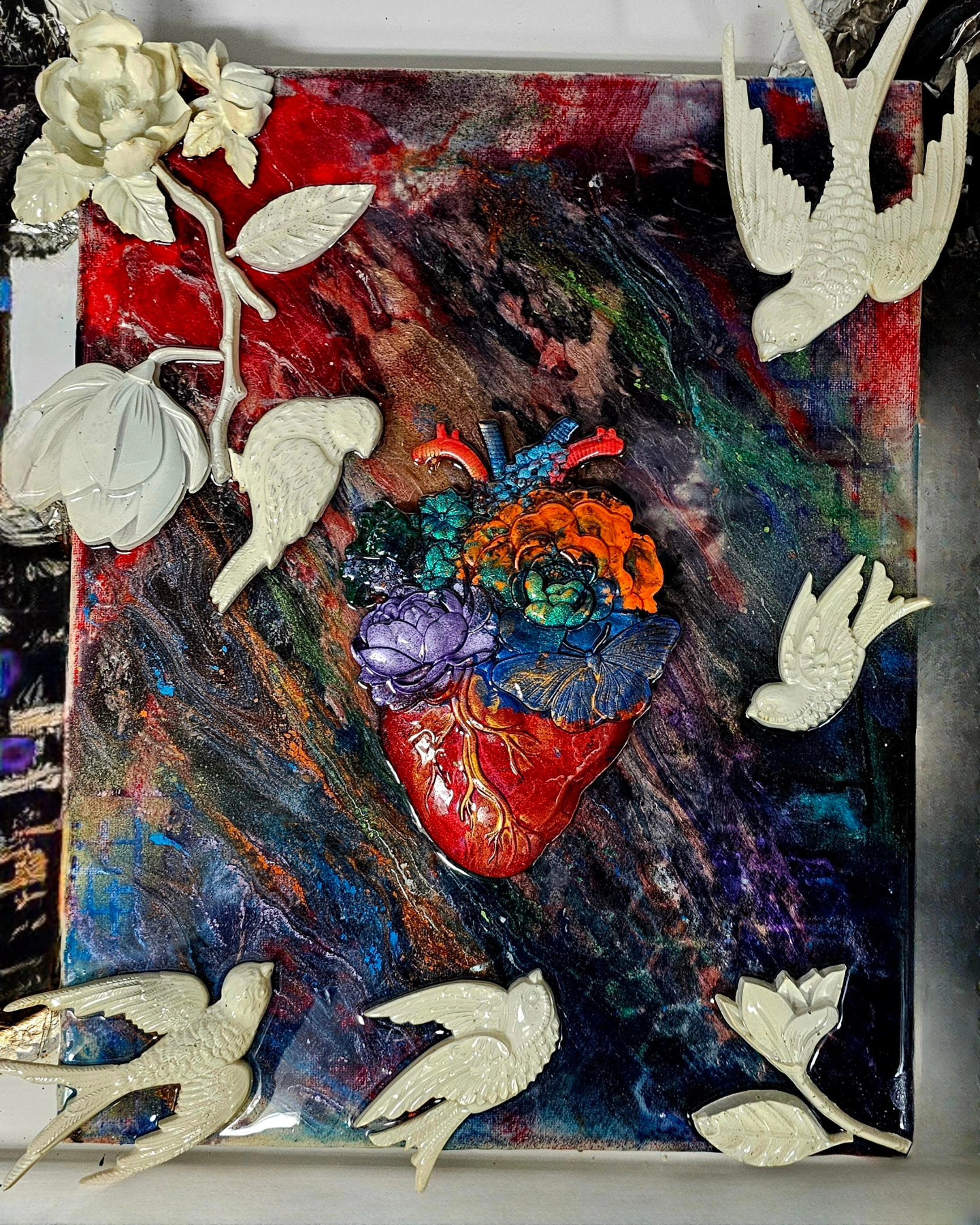 Mixed media artwork with an anatomical heart, flowers, and birds