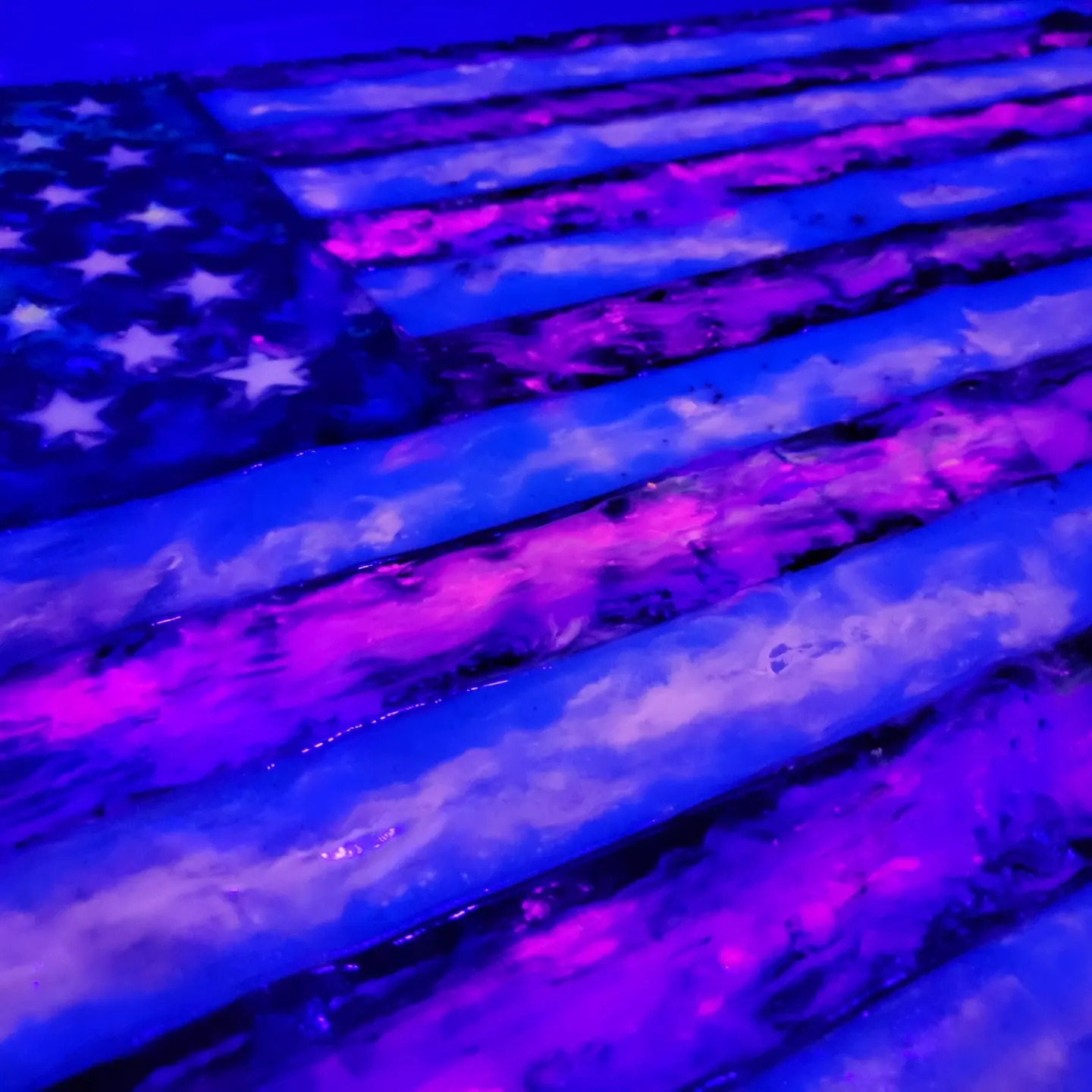 American flag artwork glowing blue and pink under black light