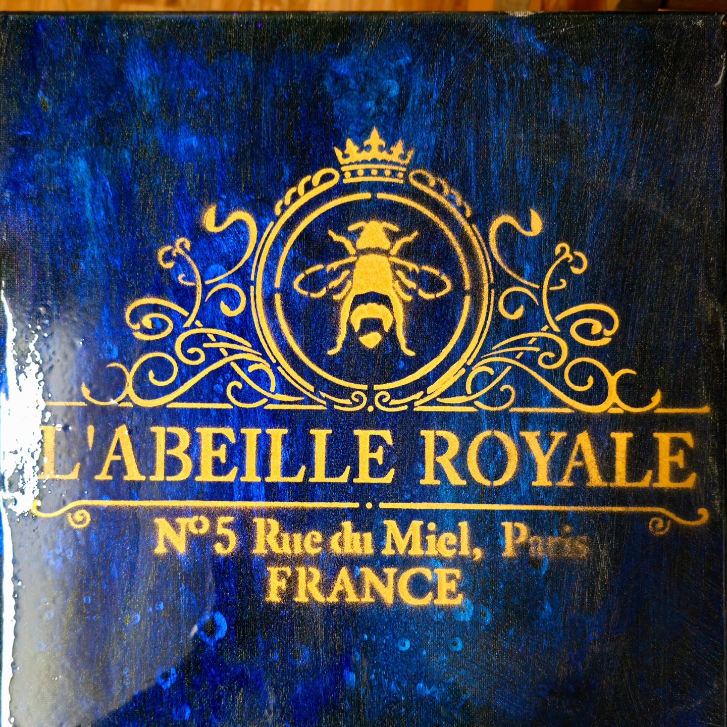Gold royal bee stencil over deep blue texture